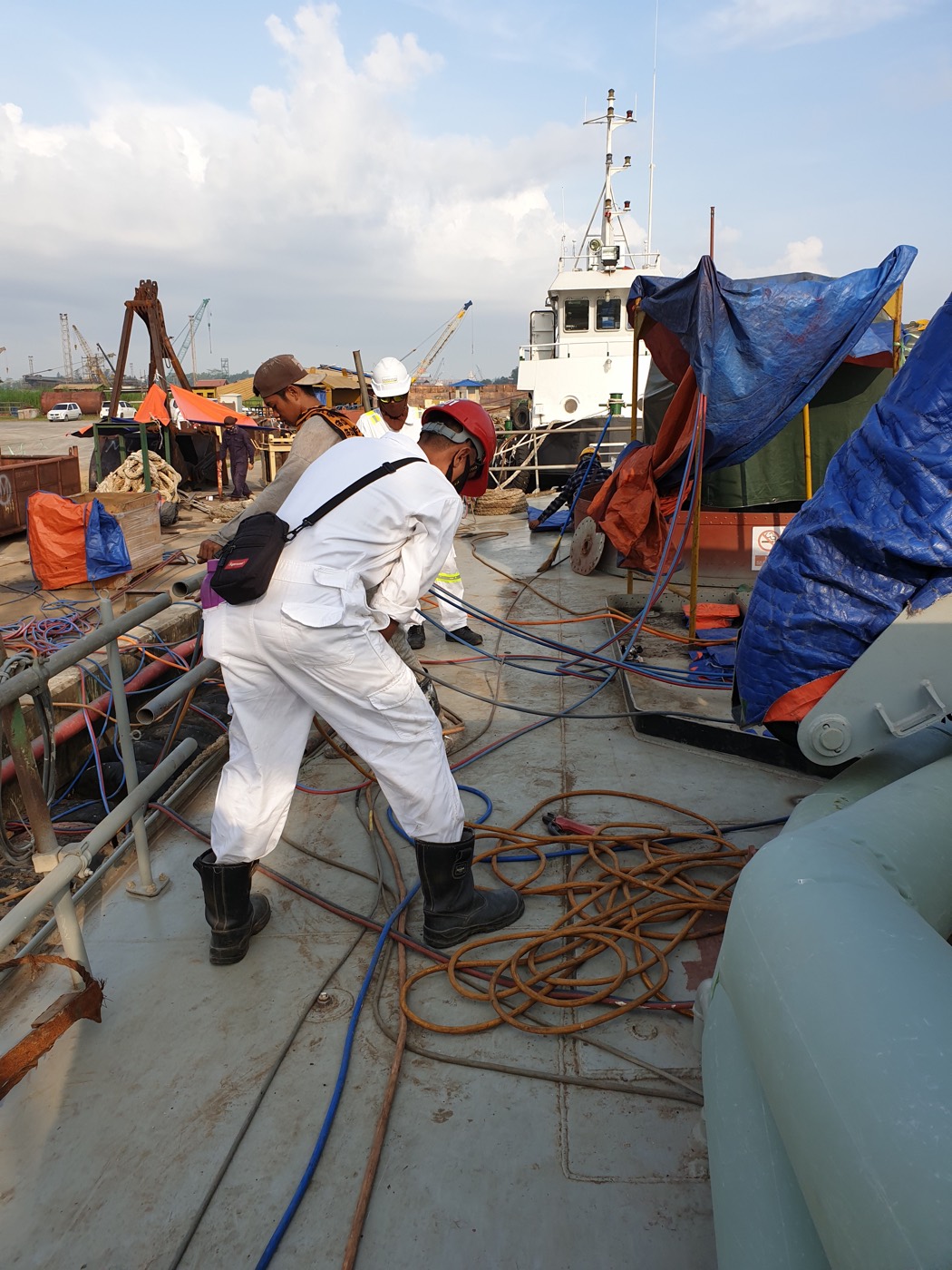 Worker pulling cable on the deck of the patrol boat
